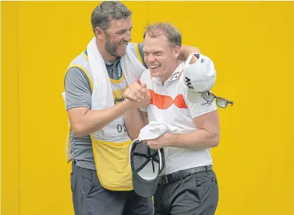  ??  ?? Danny Willett celebrates his birdie with David Lipsky’s caddie on the 18th hole.