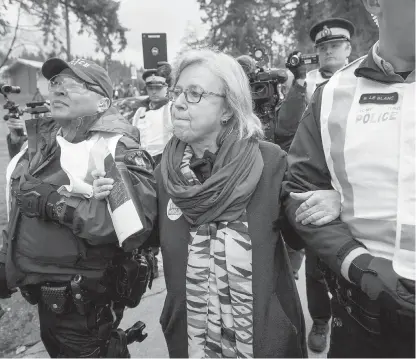  ??  ?? Federal Green Party Leader Elizabeth May, centre, is arrested by RCMP officers after joining protesters outside Kinder Morgan's facility in Burnaby on March 23.