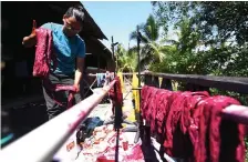  ??  ?? A worker arranges the fabrics to be dried under the sun.