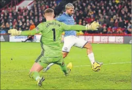  ??  ?? City's Sergio Aguero scores past Sheffield United keeper Dean Henderson on Tuesday.
AFP