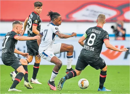  ??  ?? TUSSLE: Rangers midfielder Joe Aribo, centre, and Bayer Leverkusen’s Lars Bender, right, battle for the ball during last night’s last-16 tie