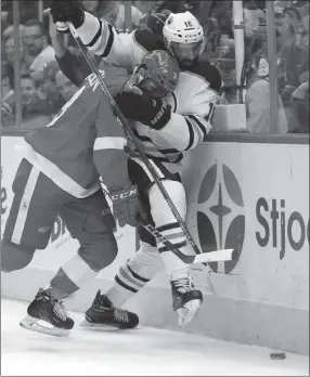  ?? The Canadian Press ?? Detroit Red Wings defenseman Nick Jensen pins Edmonton Oilers left wing Jujhar Khaira against the boards last Wednesday in Detroit.