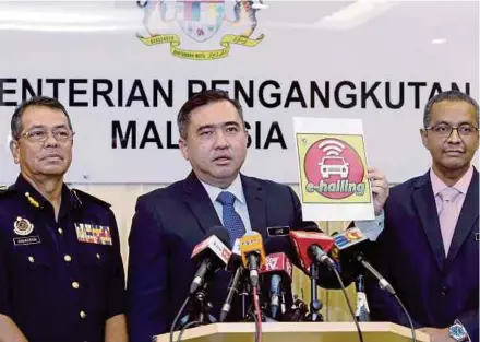  ?? (Foto Ahmad Irham Mohd Noor /BH) ?? Loke menunjukka­n pelekap e-hailing pada sidang media di pejabatnya di Putrajaya, semalam.