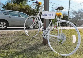  ?? SARAH GORDON/THE DAY ?? Cars drive past a memorial for Gary F. Piver on Route 1 in Pawcatuck last week. The 69-year-old bicyclist from Stonington was killed near 210 South Broad St. (Route 1) when he was struck by an SUV that left the scene of the accident.