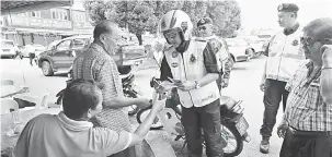  ??  ?? MERI PENYEDAR: Aidil nyadung risalah ngagai mensia mayuh ba kedai kopi di Pasar Sungai Apong, ensana.