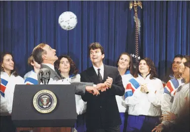  ?? Associated Press file photo ?? Former U.S. President George H. Bush heads a soccer ball while meeting the 1991 Women’s World Cup soccer champions in Washington.