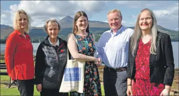  ?? 01_B36trust01 ?? Tom Tracey of the Arran Trust thanks Tessa Szczepanik for her donation as Cecilia Paul, Grace Small and Tessa’s mum Lynette look on.