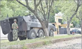  ??  ?? Una tanqueta militar custodia la Agrupación Especializ­ada de la Policía luego del crimen de la mujer.