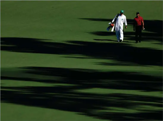  ?? ?? Tiger Woods and his caddie Lance Bennett walk across the second hole during the final round of the 2024 Masters at Augusta National