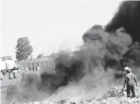  ??  ?? While some people recycle plastics, these men decide to burn the waste causing serious pollution at an industrial area in Bulawayo recently. (Picture by Eliah Saushoma)