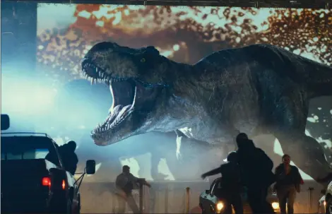  ?? UNIVERSAL PICTURES ?? A dinosaur sends a panicked crowd scrambling at the drive-in in ‘Jurassic World: Dominion.’