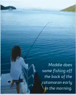  ?? ?? Maddie does some fishing off
the back of the catamaran early
in the morning.