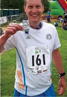  ??  ?? Cleaning up: Red Williams shows off his medal after competing in the Windermere marathon in May