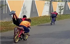  ??  ?? Dangerous pastime: ‘Mat lajaks’ doing daring stunts while riding their modified bicycles near Taman Kulai Utama in Kulai, Johor.