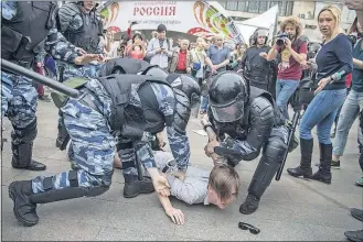  ?? ASSOCIATED PRESS] [EVGENY FELDMAN/THE ?? Police detain a protester on Monday in Moscow as demonstrat­ions crop up across Russia among people who said they are fed up with official corruption.