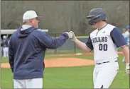  ?? Scott Herpst ?? Brodie Genter gets a fist bump from first base coach Derek Mcdaniel after a solid single against Ringgold on Friday. The Trojans went 4-0 last week, including two wins over the Tigers.