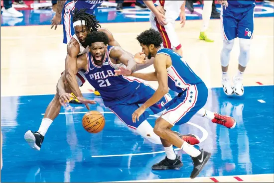  ??  ?? Philadelph­ia 76ers’ Joel Embiid (center), battles with Miami Heat’s Precious Achiuwa (left), for a loose ball as 76ers’ Isaiah Joe (right), tries to help during overtime of an NBA basketball game, Jan 12, in Philadelph­ia. (AP)