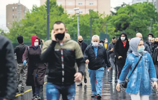  ??  ?? Commuters wearing protective masks walk on a street in Istanbul, Turkey, May 27, 2020.