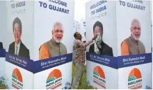  ?? Reuters-Yonhap ?? A worker cleans a hoarding featuring India’s Prime Minister Narendra Modi and Japanese Prime Minis- ter Shinzo Abe ahead of Abe’s visit in Ahmedabad, India, Sunday.