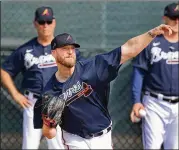  ?? CURTIS COMPTON / CCOMPTON@AJC.COM ?? Manager Brian Snitker (left) watches reliever Will Smith work during spring training Feb. 13 in Florida. Smith is close to a return.