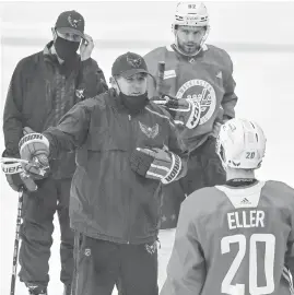  ?? RICKY CARIOTI/ AP ?? Capitals coach Peter Laviolette, center left, talks to his players during practice at the MedStar Capitals Iceplex in Arlington, Va.,