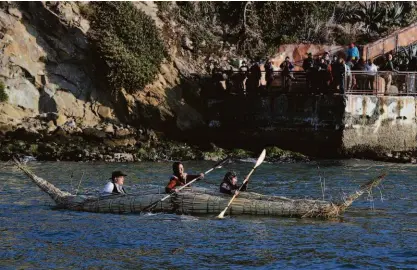  ?? Carlos Avila Gonzalez / The Chronicle 2019 ?? Alfonso Ramirez, Jackie Fielder and Antonio Moreno paddled their tule reed canoe past a crowd after the 2019 Indigenous Peoples Day Sunrise Ceremony on Alcatraz Island.