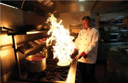  ?? AP FOTO ?? PLAYING WITH
FIRE. Chef Mohammed Fatzul Haque prepares a dish at the Taste of India curry restaurant in London. Curry shop owners fear that the onset of Brexit will force many of their shops to close.