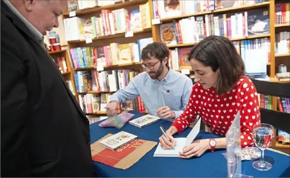  ?? Pam Panchak/Post-Gazette ?? Local authors Boaz Frankel and Brook Barker sign their new book, “Let’s Be Weird Together,” for local celebrity Rick Sebak during a date night extravagan­za at Riverstone Books in McCandless.