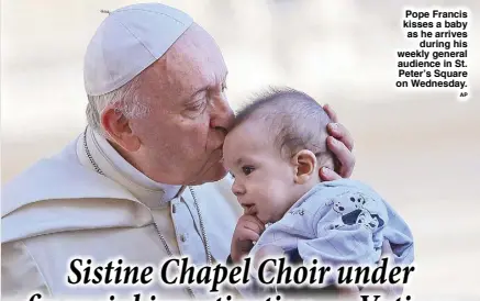  ?? AP ?? Pope Francis kisses a baby as he arrives during his weekly general audience in St. Peter’s Square on Wednesday.