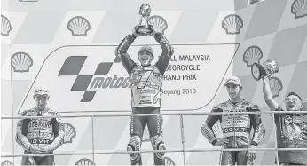  ?? — Gambar Bernama ?? HEBAT: Martin (tengah) menjulang trofi kejuaraan selepas menamatkan perlumbaan kelas Moto3 pada Grand Prix Malaysia 2018 di Litar Antarabang­sa Sepang semalam.