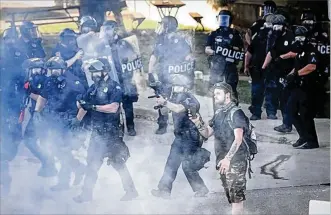  ?? MARSHALL GORBY / STAFF ?? Dayton police deploy tear gas to disperse the crowd of protesters on Saturday, May 30. A few messages expressed appreciati­on and support of the Dayton Police Department.