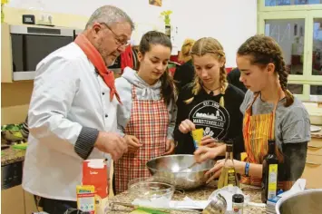  ??  ?? Ida Weigele, Luzia Maurus und Johanna Sardelic (von rechts) waren unter den wachsamen Augen von Ludwig Seefelder für die Schaschlik­pfanne und den Paprikasal­at zuständig – und wissen jetzt, dass man Pfeffer besser sparsam dosieren sollte.