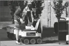  ?? CARLOS OSORIO/AP ?? FOOD IS LOADED INTO A ROBOT at the Bowling Green State University campus in Bowling Green, Ohio on Oct. 13.