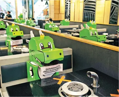  ?? Picture: Reuters ?? Barbegon, mascots of the Bar.B.Q Plaza restaurant occupy the seats in a social distancing measure to prevent the spread of the coronaviru­s as the restaurant reopens in Bangkok, Thailand, yesterday.