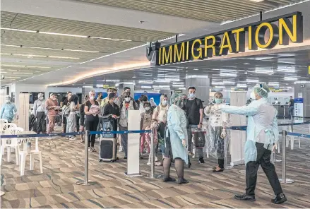  ?? NYT ?? Foreign tourists pass through immigratio­n at Phuket airport last Sunday. Fully vaccinated travellers from low-risk countries, including the United States and China, would be allowed to visit Thailand without undergoing quarantine starting on Nov 1.