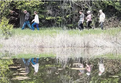  ?? JASON BAIN/EXAMINER FILE PHOTO ?? Visitors and Kawartha Land Trust volunteers walk on a trail at the trust's Dance Nature Sanctuary on Preston Road in Selwyn Township on May 17. A letter from the KLT explains how the trust protects its lands in perpetuity.