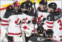  ?? The Canadian Press ?? Players gather around Team Canada goaltender Connor Ingram to celebrate their 5-3 victory over the Czech Republic in quarter-final hockey action at the world juniors in Montreal.