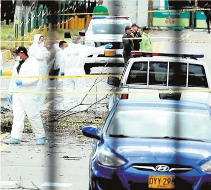  ?? EFE ?? Investigad­ores, en el lugar donde explotó un vehículo bomba en la Escuela de la Policía en Bogotá