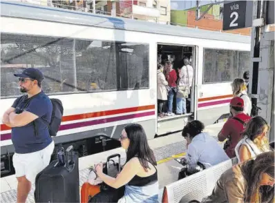  ?? Àlex Recolons / ACN ?? Viatgers esperen el seu tren, ahir, a l’estació de Castelldef­els.