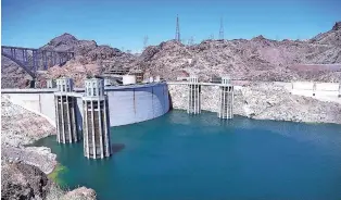  ?? ASSOCIATED PRESS FILE PHOTO ?? The low level of the water line is shown on the banks of the Colorado River on May 31 at the Hoover Dam in Hoover Dam, Ariz. U.S. officials say the chances of a shortage in the vital Colorado River system have risen to 57 percent by 2020.