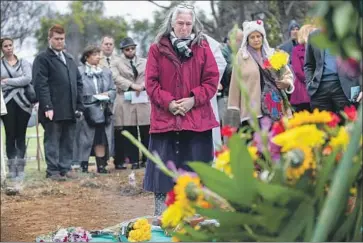  ?? Photograph­s by Allen J. Schaben Los Angeles Times ?? SUSAN RORKE, who needed a fee waiver to claim her sister’s ashes before the group burial three years ago, joins others to pay respects to the unclaimed remains of more than 1,400 people, most of whom died in 2015.