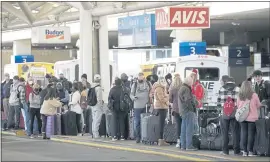  ?? DAVID ZALUBOWSKI — THE ASSOCIATED PRESS ?? Travelers queue up for shuttle buses to rental car lots at Denver Internatio­nal Airport Sunday in Denver.