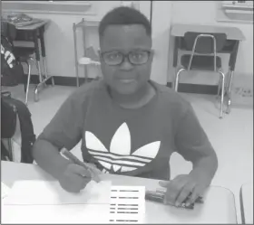  ??  ?? Coding: Using Ozobot markers, third-grader Lamarion Robinson designs a code to manipulate a robot.