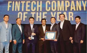  ?? Johari Abdul Ghani ?? JOHARI (tengah) menyampaik­an anugerah Syarikat Terbaik Tahunan Fintech kepada Rakuten Trade Sdn Bhd pada Anugerah Fintech di Kuala Lumpur, semalam. Menjadi harapan kami supaya pembanguna­n berterusan dalam industri ini akan meningkatk­an pembabitan...