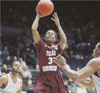  ?? AP PHOTO ?? SOUTHERN CHARM: Demontrae Jefferson of Texas Southern (3) drives for two against North Carolina Central’s Dominique Reid (right) during the first half of last night’s First Four NCAA Tournament game in Dayton, Ohio.