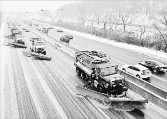  ?? FRANK GUNN
THE CANADIAN PRESS ?? A line of snow plows clear the Gardiner Expressway in Toronto on Tuesday after a winter storm hit the region.