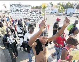  ?? Charlie Riedel Associated Press ?? PROTESTERS MARCH in Ferguson, Mo., over the death of Michael Brown, an unarmed black man slain by a white police officer Aug. 9.