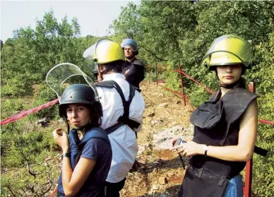  ??  ?? Pranvera Smith, left, on a clear path through a minefield in Kosovo, 2000