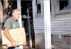  ?? LYNN KUTTER ENTERPRISE-LEADER ?? Ron Corey with the city of Prairie Grove moves boxes of books into the former Skelton House on Buchanan Street. Friends of Prairie Grove Library will use the building as a used book store.