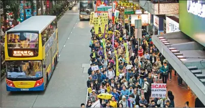  ??  ?? 香港特首選舉撕裂民意，圖為香港民眾在投票前­夕上街，要求實施真普選。(Getty Images)